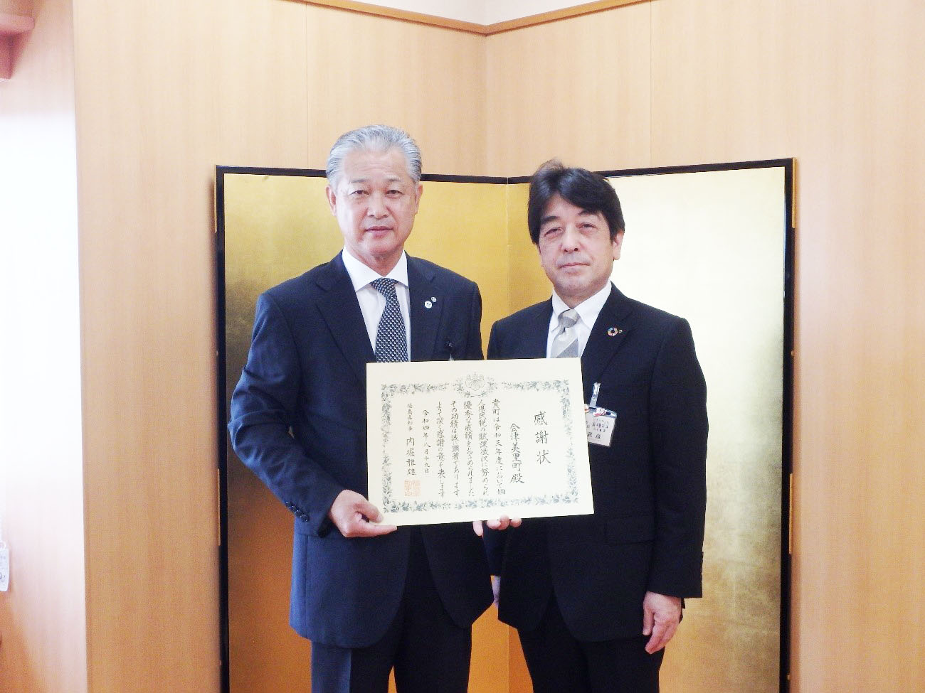 感謝状を持ちながら高野局長と町長が並んで記念撮影をしている写真