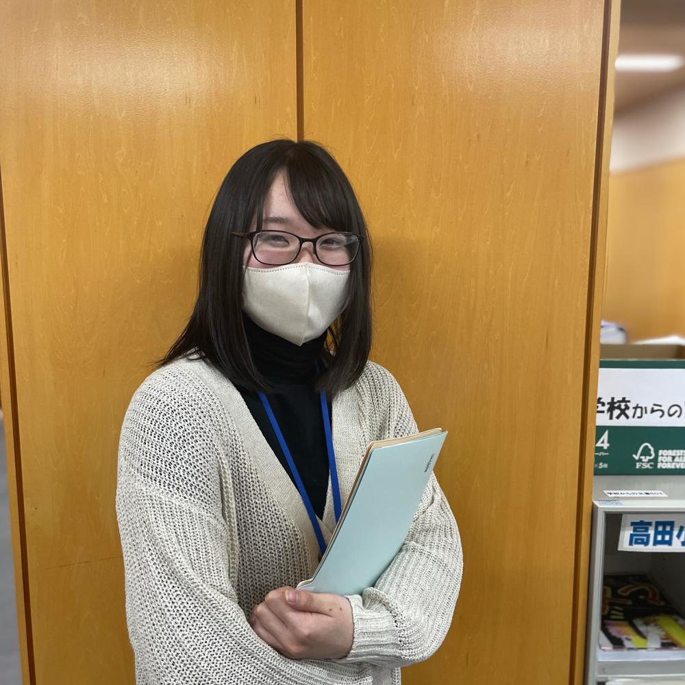 書類を持ち笑顔の安部千尋さんの写真