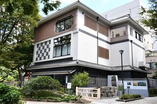 左脇に大きな樹木があり、白を基調とし2階部分に大きな窓があり瓦屋根のしたまちミュージアムの写真