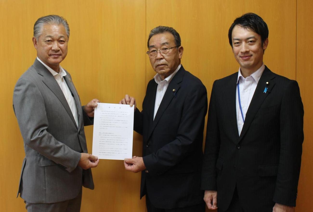 スーツを着た3人の男性が横一列に並び、杉山町長と横山議長が一緒に提言書を持っている写真