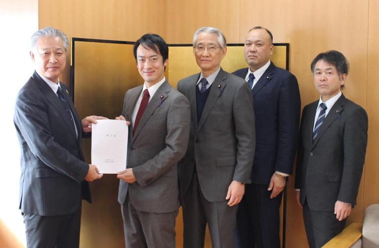 スーツを着た5人が横一列に並び、杉山町長と大竹議長が一緒に提言書を持っている写真