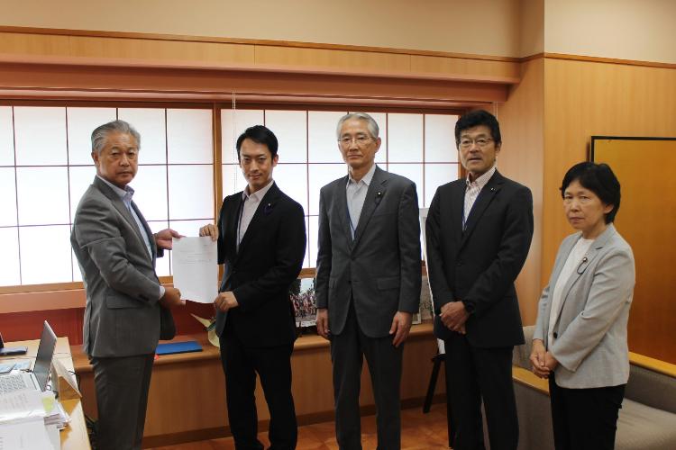 スーツを着た5人が横一列に並び、杉山町長と大竹議長が一緒に提言書を持っている写真