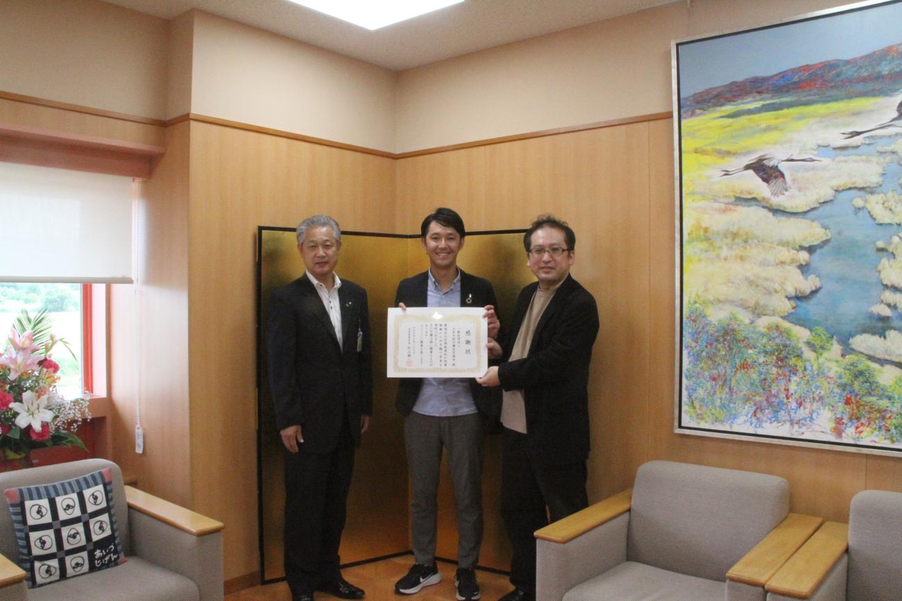 町長（左）と賞状を持った一般社団法人日本木造分譲住宅協会様（中央と右）が一緒に記念撮影をしている写真