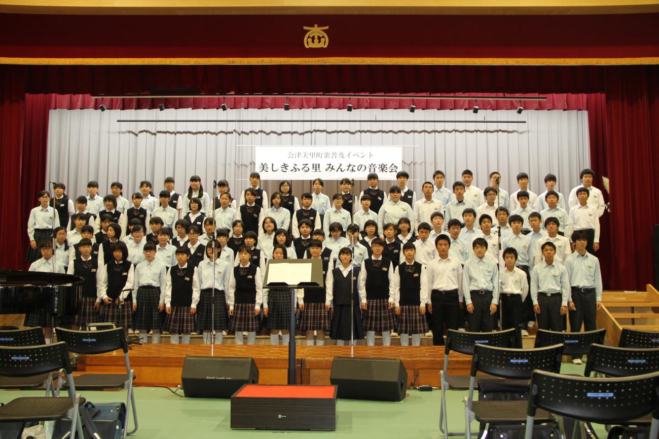 舞台に5列に並んだ生徒たちが合唱をしている写真
