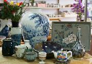青で色付けされた花瓶やお皿、花が描かれた急須の会津本郷焼がテーブルに並べられている写真