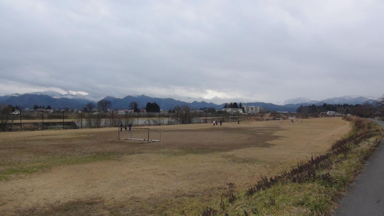 道路の横にある河川敷の宮川運動場の写真